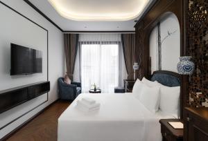 河内Eli Rina Hotel的一间酒店客房,配有白色的床和电视