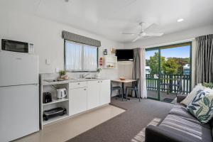 米兰达Tasman Holiday Parks - Miranda的厨房以及带沙发和桌子的客厅。