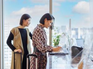 福冈博多瑞索尔三一酒店的两名妇女站在办公室里看笔记本电脑