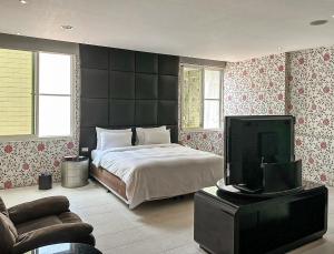 竹山欧游国际连锁精品旅馆的一间卧室配有一张床和一台平面电视
