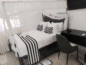 基苏木Skybeach apartment的卧室配有白色的床和黑白色枕头