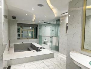 竹山欧游国际连锁精品旅馆的带浴缸和卫生间的大型浴室