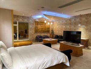 竹山欧游国际连锁精品旅馆的酒店客房,配有床和电视