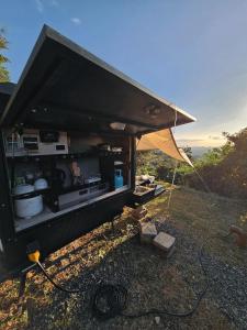 San MateoUCM Adventure Park的一辆黑色食物车,在山坡上搭帐篷