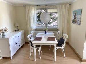 施莱茨NEU! Moderne Fewo Schieke的白色的用餐室配有白色的桌椅