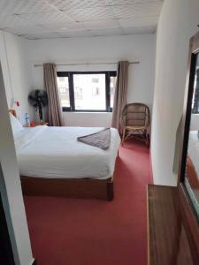 班迪普尔Good Hotel的卧室配有床、椅子和窗户。