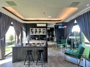 马尼拉Azumi Boutique Hotel的一个带绿色椅子的沙龙和客房内的酒吧