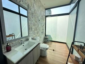 马尼拉Azumi Boutique Hotel的一间带水槽和卫生间的浴室以及窗户。