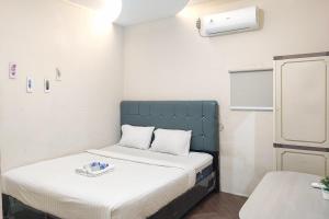 PaalmerahRedDoorz Syariah near Transmart Jambi的一间小房间,内设两张床