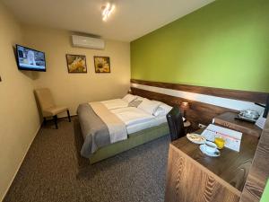 班斯卡-比斯特里察Hotel Garni Expo的酒店客房配有一张床铺和一张桌子。