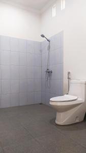 森纳儒Embun Rinjani Homestay的白色的浴室设有卫生间和淋浴。
