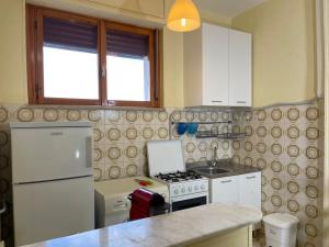 坎波马里诺Appartamento Ciclamini的厨房配有炉灶和白色冰箱。