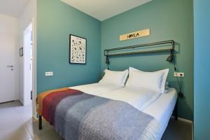 霍尔斯沃德吕尔米加德酒店的一间卧室配有一张蓝色墙壁的床