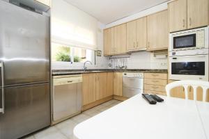 雷乌斯AIGUESVERDS HomeStay By Turismar的厨房配有木制橱柜和不锈钢冰箱。