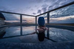 霍尔斯沃德吕尔米加德酒店的坐在游泳池里看着日落的小女孩