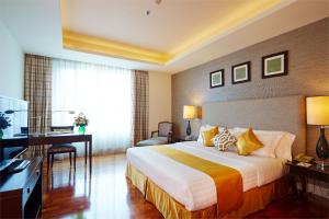 曼谷The Duchess Hotel的配有一张床和一张书桌的酒店客房