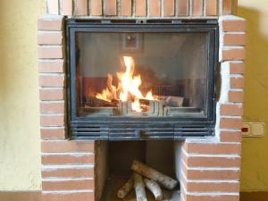 埃尔韦鲁埃科拉德埃萨阿罗雅蜜恩拖斯酒店的砖砌壁炉,壁炉里放着火