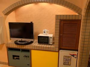 Iwakiriホテル　プレリュード的一间带电视和微波炉的厨房