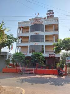 比拉斯布尔Hotel Shubh Shree Bilaspur的前面有树木的白色大建筑