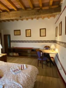佩萨河谷塔瓦内莱Campora House的卧室配有一张床和一张桌子及椅子