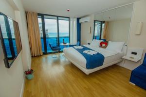 巴统Orbi Hotel City Batumi View的酒店客房设有一张大床和一张桌子。