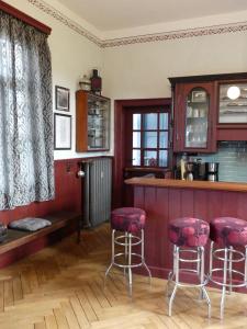 MeederFerienwohnung Bahnhof 1892的厨房设有带红色凳子的酒吧