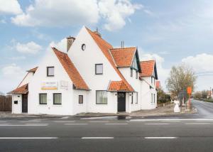 米德尔克尔克Zeegalm Bungalows的白色的建筑,在街上有橙色的屋顶