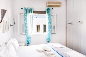 RóziaGarden Apartments的白色卧室配有蓝色窗帘和床