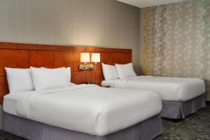 Stow阿克伦斯托万怡酒店的配有白色枕头的酒店客房内的两张床