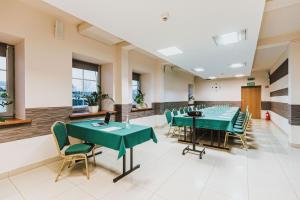 拉多姆葛洛马达拉多姆中枢酒店的一间会议室,配有绿色的桌椅
