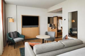 曼彻斯特Manchester Marriott Hotel Piccadilly的客厅配有沙发、椅子和电视