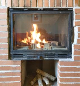 埃尔韦鲁埃科卡斯蒂略住宿酒店的砖砌壁炉,壁炉里放着火