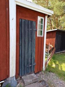 KvillsforsHemma fran Hemma - Stuga的房屋一侧有门的木棚