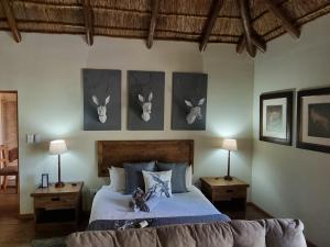 侯斯普瑞特Paradise River Lodge的卧室配有一张床铺,墙上挂着鹿角