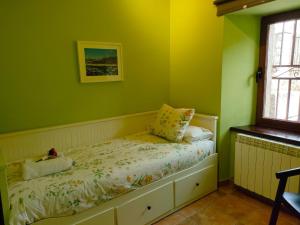 埃尔韦鲁埃科Alojamiento Antigua Casa de Telefonos的一间卧室设有绿色的墙壁和一张带枕头的床