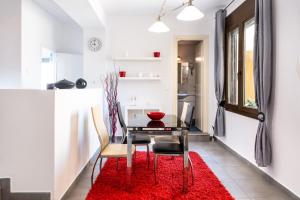 RóziaGarden Apartments的一间设有桌子和红色地毯的用餐室