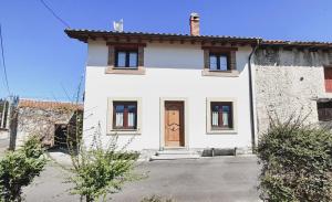 Casa para 5 personas con terreno en La Franca的一间白色的房子,设有棕色的门