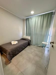 瓦伦西亚竞技场酒店的一间卧室配有一张床、一张桌子和一个窗户。