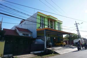 SungguminasaOYO 93877 Atifah Homes的一座绿色和黄色房子
