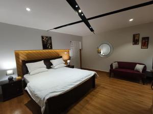 穆里Royal Resort的一间卧室配有一张大床和一张红色椅子