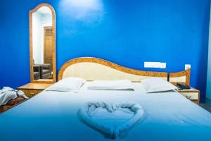 普里Hotel Raj的蓝色的床,上面有心形枕头