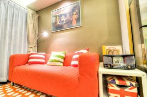 拉威海滩普吉岛标题精品公寓的客厅配有带色彩缤纷枕头的橙色沙发