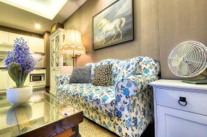 拉威海滩普吉岛标题精品公寓的客厅配有蓝色和白色的沙发和风扇