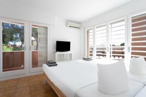 卡斯特尔德费尔斯Canela Homes COSTA CASA AILA的一间白色卧室,配有床和电视