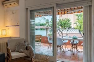 卡斯特尔德费尔斯Canela Homes COSTA CASA AILA的客厅设有一扇门,可通往带桌子的庭院。