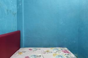 PallengukOYO 93875 Tifar House的蓝色墙壁间的一张床位