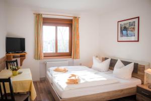 Gasthof Blankenberg的一间卧室配有一张床、一张桌子和一个窗户。