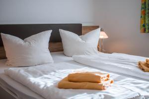 Gasthof Blankenberg的两张带白色床单的床、枕头和毛巾