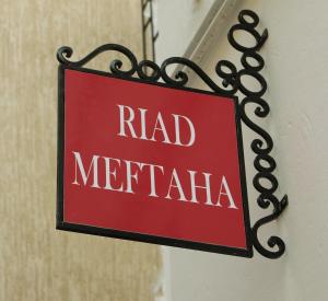 拉巴特梅塔哈摩洛哥传统庭院住宅旅馆的挂在建筑物上的红色标志,上面写着头脑炎