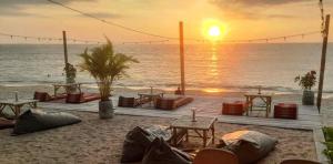 高兰Scandinavian Beach Resort的海滩上的日落美景,配有桌椅